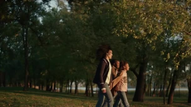 Familjevandring höst park hålla händerna tillsammans i kväll gyllene solljus. — Stockvideo