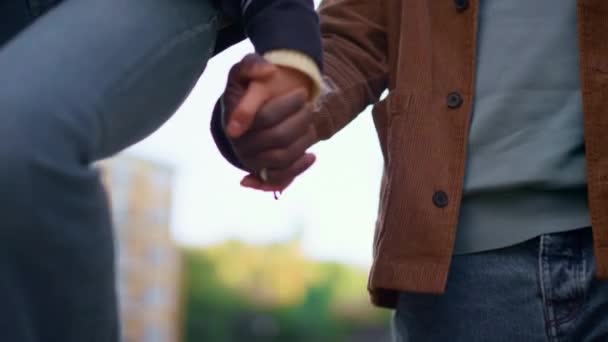 Couple holding hands together walking at defocused street sky background closeup — Stock Video