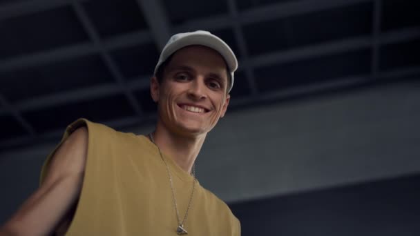 Un uomo felice che guarda la telecamera allo skate park. Ritratto di pattinatore sorridente all'aperto. — Video Stock