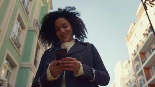 Femme souriante tenant smartphone marchant ensoleillé matin gros plan. Heureux utilisateur app. — Video