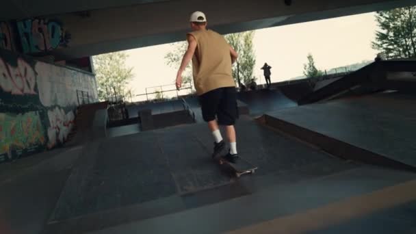 Giovane pattinatore a cavallo su skateboard in città skatepark. Ragazzo salto skate board. — Video Stock