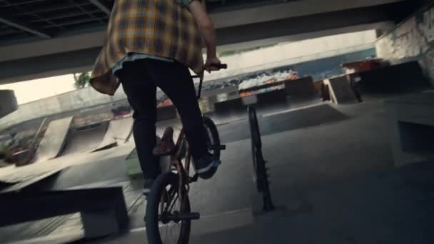 Sportovní jezdec provádějící triky na kole bmx ve městě skateboarding park. — Stock video