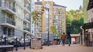 Günümüz modern binalarının dikiz aynasından yürüyen neşeli bir çift. Mutlu genç kız dansı