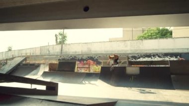 Sıradan bir BMX sürücüsü, şehir kaykay parkında bisikletle rampada numaralar yapıyor.. 