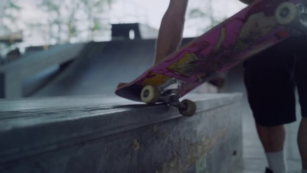 Muž ruce dotýká skateboard kola v skate parku. Jízda na skateboardu kolo. — Stock video
