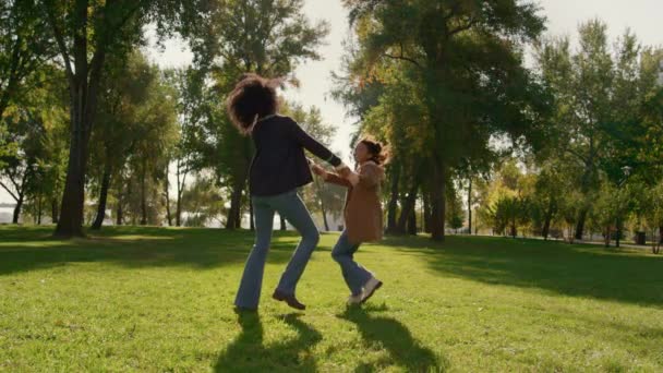 Улыбающаяся мать играет вместе дочь танцует на зеленом весеннем поле парка. — стоковое видео