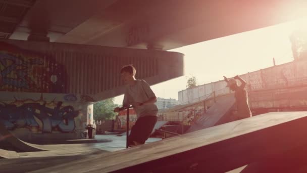 Adolescentes deportistas practican la competición juntos en el parque de skate urbano. — Vídeos de Stock