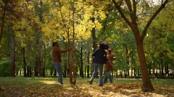 Eltern Tochter ruhen Herbst Park genießen warmes Sonnenlicht. Frohes unbeschwertes Wochenende — Stockvideo