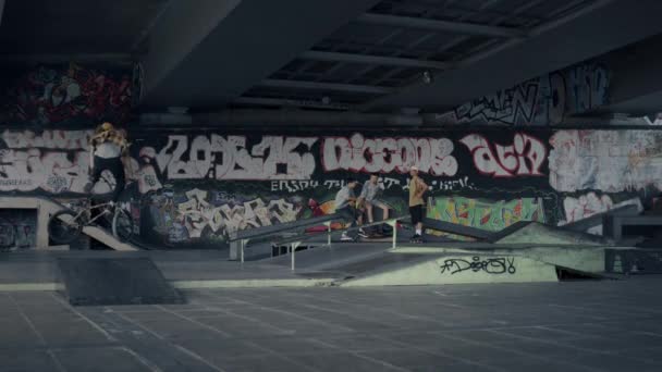 Extremo homem realizando salto acrobacia na bicicleta bmx no parque de skate com graffiti. — Vídeo de Stock