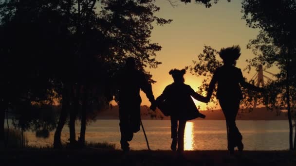 Casal de filha silhueta correndo na vista do pôr do sol do rio. Cuidar das pessoas juntas. — Vídeo de Stock