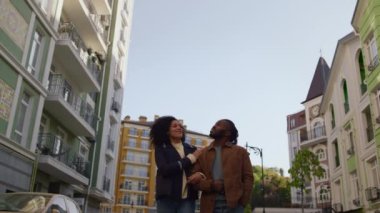 Mutlu çift birlikte binalara bakıyor modern sakin yerleşim yerlerini geziyorlar..