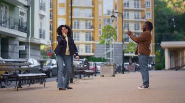 Mutlu kız sokakta sosyal medya hesabı için moda dans videosu kaydediyor.