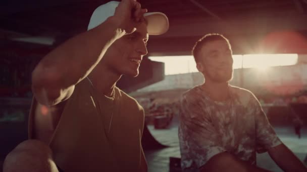 Stylové hipsteři relaxační skatepark za slunečních paprsků. Přátelé spolu mluví. — Stock video