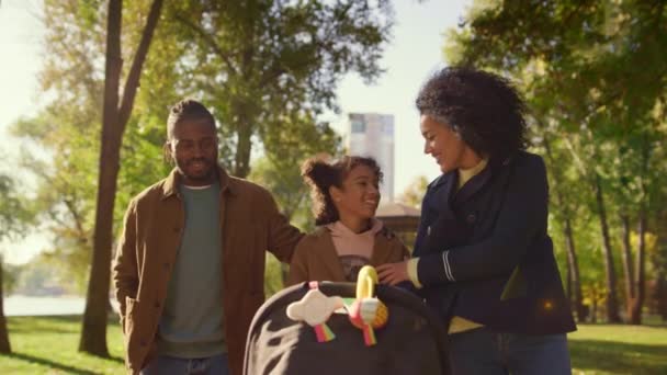 Szczęśliwa rodzinna rozmowa spacerująca razem w słonecznym parku. Radosny rodzinny weekend. — Wideo stockowe