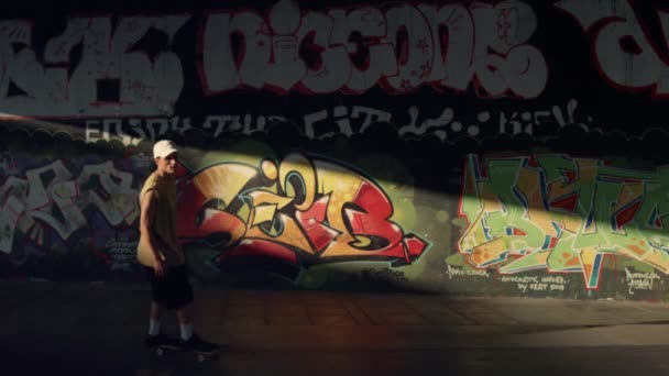 Mladý bruslař jezdí na skateboardu v skate parku. Sportovní hipster skateboarding. — Stock video