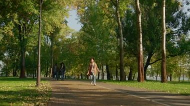 Güneşli sıcak bir akşamda mutlu aile parkı. Neşeli kız zıplıyor