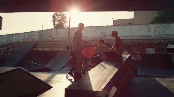 Jóvenes comunicándose en el parque de patinaje. Jinetes discutiendo sesión de entrenamiento. — Vídeos de Stock