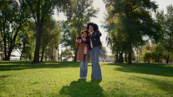 Mãe feliz fazendo chamada on-line com bonito sorrindo filha de pé no parque. — Vídeo de Stock