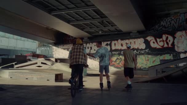 Jeunes coureurs parlant ensemble au skate park graffiti. amis actifs équitation — Video