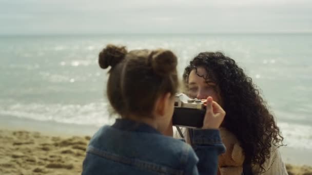Madre hija tomando fotos en la playa del mar. Familia relajándose juntos en la costa. — Vídeo de stock