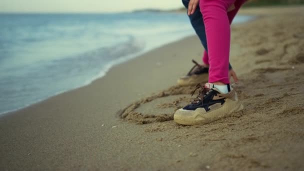 Dzieciak stojący na piaskowej plaży w morskiej naturze. Trampki z nogami dziewczynki bawią się na zewnątrz. — Wideo stockowe