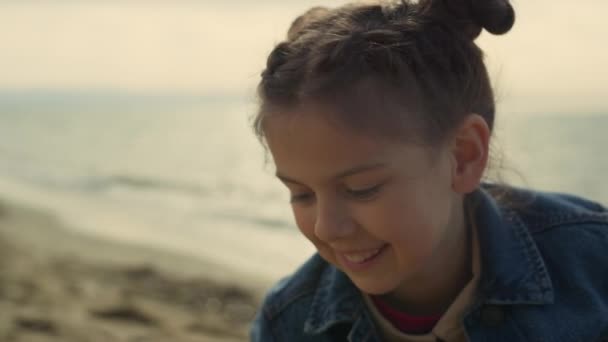 ยิ้มสาวเล่นชายหาดในวันหยุดฤดูร้อน เด็กที่มีความสุข มีความสนุกสนานริมทะเล . — วีดีโอสต็อก