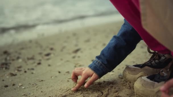 Mały dzieciak rysujący piasek na plaży oceanu. Dzieci bawią się dłońmi na brzegu morza — Wideo stockowe