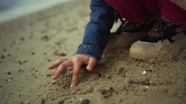 Des mains d'enfant dessinant du sable. Jeune fille enfant s'amuser à la mer plage nature en plein air — Video