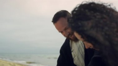 Deniz kıyısı tatilinde eğlenen heyecanlı çift. İnsanlar dışarıda gülüyor.