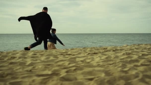 Deniz kıyısında bir aile. Baba ve kız okyanus kıyısında yarış yapıyorlar.. — Stok video