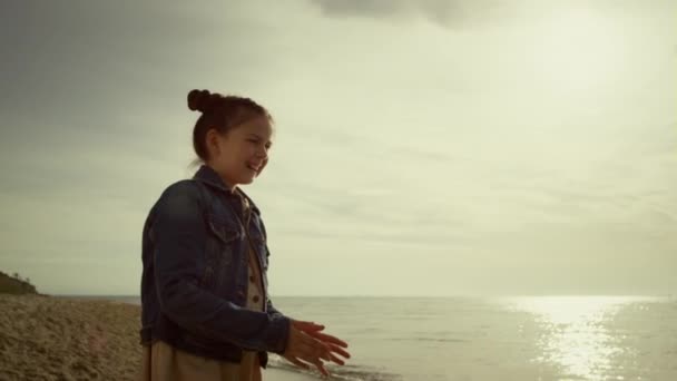 Ragazza felice sorridente godendo spiaggia di mare al mattino. Ragazzo alla ricerca di fotocamera sulla riva. — Video Stock