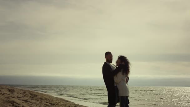 Um casal a abraçarem-se no mar. Amar as pessoas abraçando juntos na costa do oceano. — Vídeo de Stock