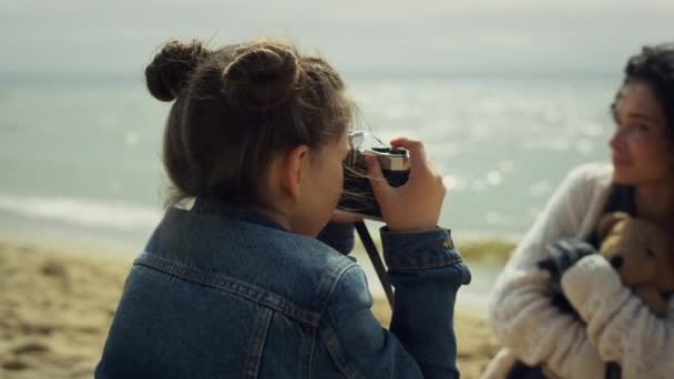 Klein meisje maakt foto 's op familie zee vakantie. Moeder dochter binding buiten. — Stockvideo