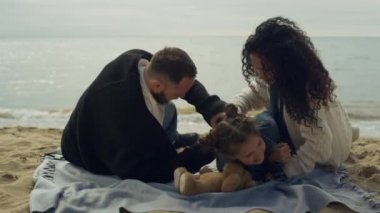 Neşeli aile deniz sahilinde piknik tatilinin tadını çıkarıyor. Mutlu insanlar dışarıda eğlenir..