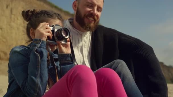 Un ragazzino che fa foto in gita in spiaggia con la famiglia. Carino ragazza tenere fotocamera al di fuori. — Video Stock