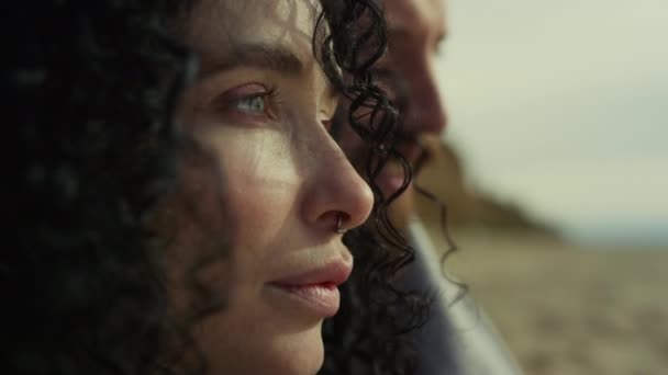 Een Spaanse vrouw met een winderige blik. Paar genieten van zee strand landschap. — Stockvideo