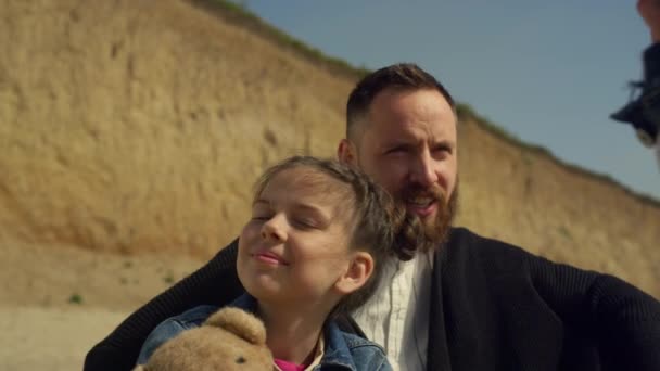 Radostná rodina pózuje venku na pláži u moře. Šťastný táta dítě mluvit o přírodě. — Stock video