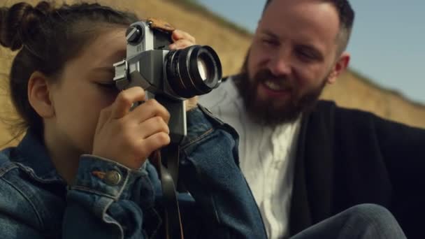 Ragazza carina con macchina fotografica scattare foto sulla vacanza in famiglia spiaggia all'aperto. — Video Stock