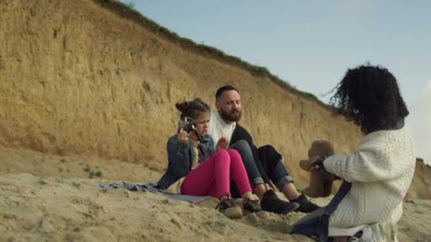 穏やかな家族は海のビーチで一緒に時間を過ごします。外で写真を撮る幸せ者 — ストック動画