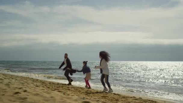 Gente saltando playa de mar. Familia juguetona disfrutar de felices vacaciones en la naturaleza junto al mar. — Vídeo de stock