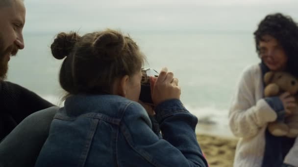 Ładna rodzina robi zdjęcia na plaży fal morskich. Mama tata dzieciak za pomocą kamery na zewnątrz. — Wideo stockowe