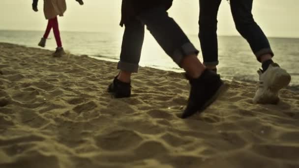 Människor ben steg stranden vid solnedgången havet natur. Familjevandring vid sandkusten. — Stockvideo