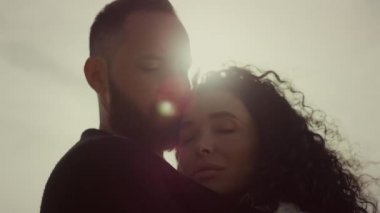 Genç çift güneş gökyüzünde birbirine sarılıyor. Sakin sevgili kız arkadaş, dışarıda rahatla.