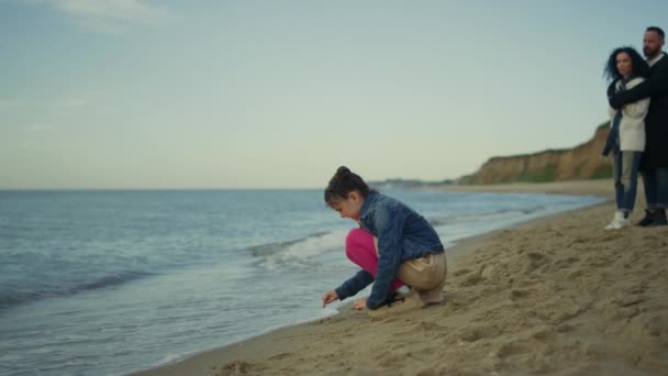 Familia joven vacaciones relajantes juntos en la playa al aire libre. Concepto de vacaciones. — Vídeo de stock