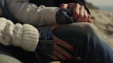 Romantik plaj buluşmasında el ele tutuşan iki kişi. Çift hafta sonu tatilinde dinlenir.