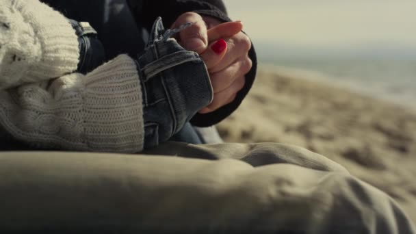 Casal romântico mãos tocando uns aos outros na praia do mar. As pessoas seguram armas lá fora — Vídeo de Stock