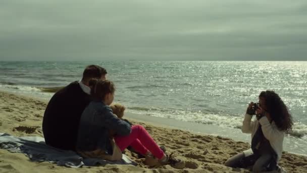Padres niño posando mar de playa. Familia joven toma fotos de la cámara por brillante océano — Vídeos de Stock