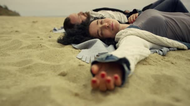 Casal hispânico areia de praia arrepiante por mar. Amantes relaxados deitados à beira-mar. — Vídeo de Stock