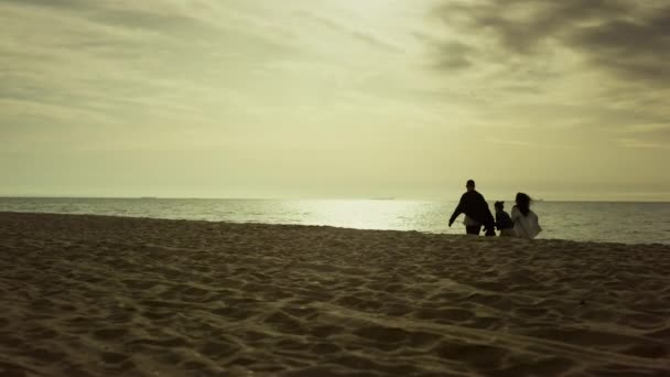 Passeggiata in famiglia insieme spiaggia al mattino. La gente gode di alba presto sulla costa del mare. — Video Stock