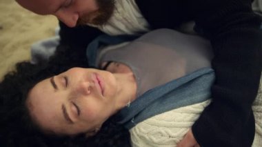 Kumsalda öpüşen uykulu çift. Sevgililer dışarıda birbirlerine sarılıyorlar.